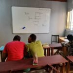 Formateur au tableau pendant un cours en petit groupe a PVT Institut